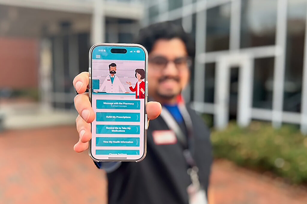 A man holds up a phone with the RxLocal pharmacy app
